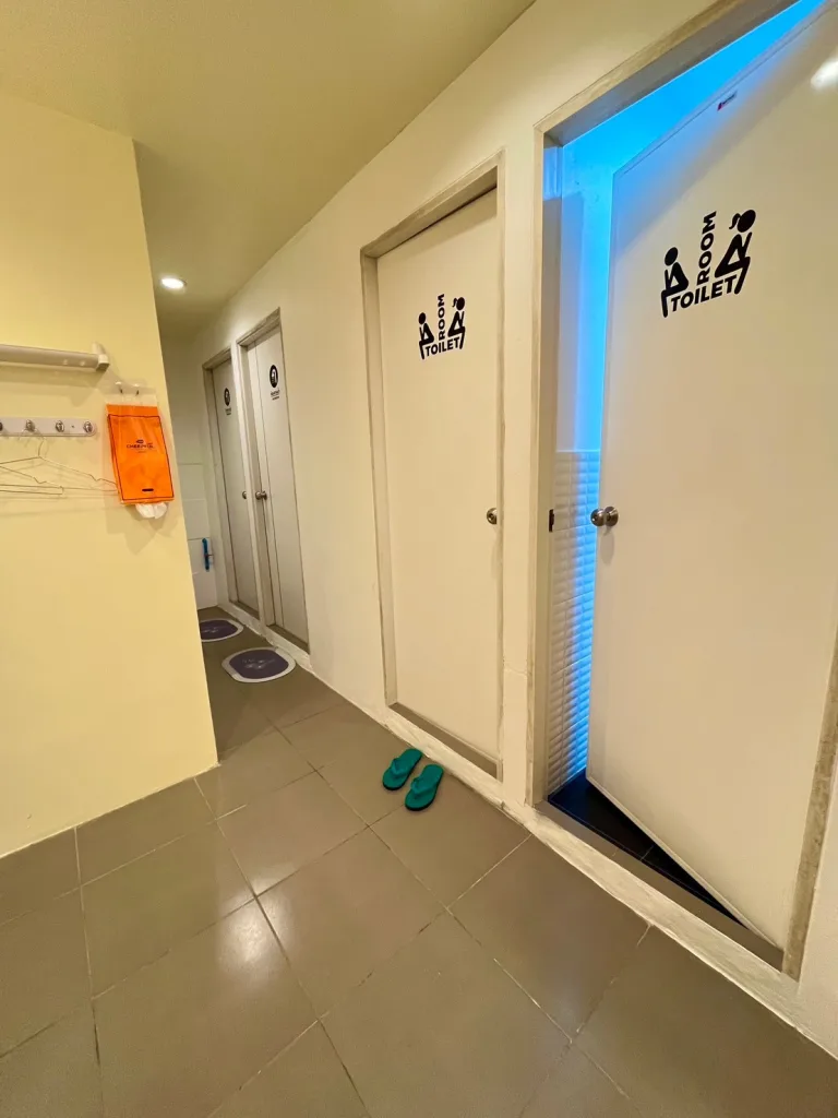 View of the bathroom showing two toilet rooms and two shower rooms at The Cocoon Hostel - Koh Samet