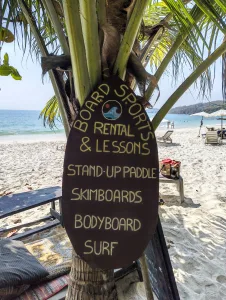 Image of the sign at flow beach advertising various watersports